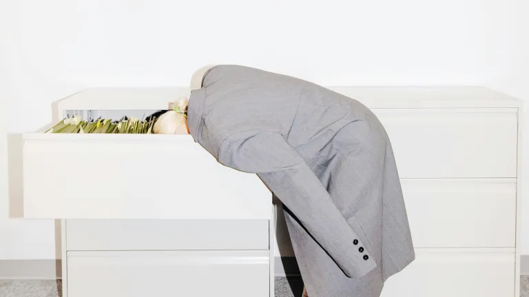 Frau versteckt ihr Gesicht in einer Schublade