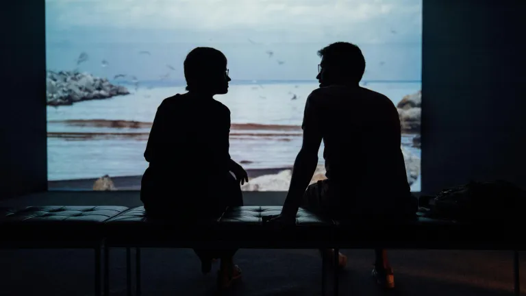 silhouettes of two people talking