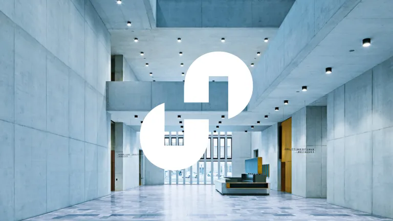 Innenansicht der Erweiterung des Kunsthaus Zürich von Chipperfield. Die große, offene Halle zeigt hoch aufragende Wände aus hellgrauem Recyclingbeton, klare geometrische Linien und eine minimalistische Ästhetik.