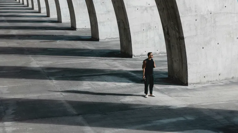 Man standing next to giant concrete columns