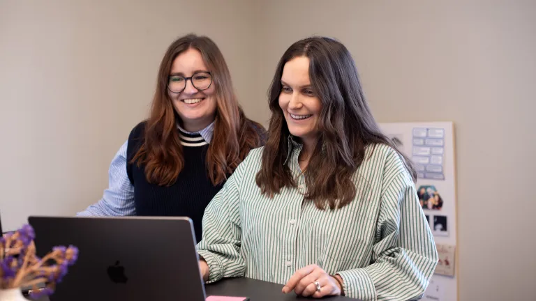 Zwei Kolleginnen halten ein Meeting am Stehpult