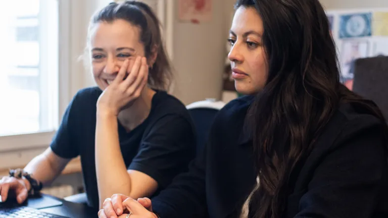 Zwei Kolleginnen halten ein Meeting am Arbeitsplatz