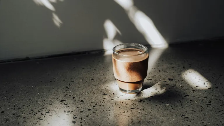Glas mit Kaffee im Sonnenlicht