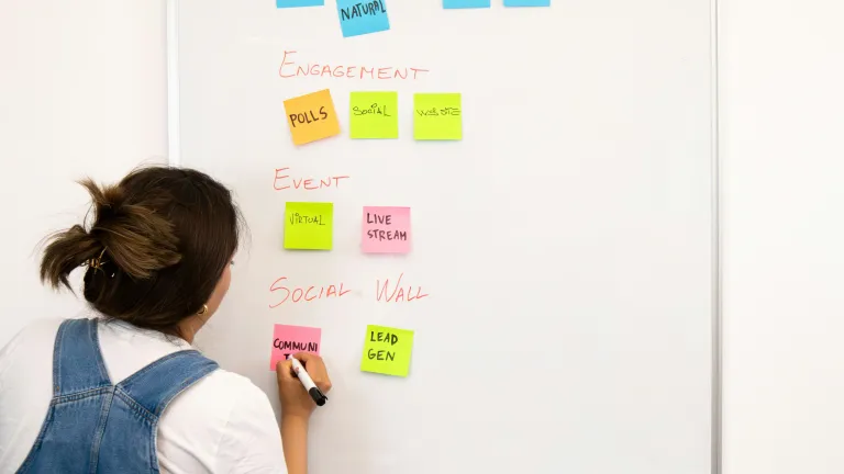 Woman writing on post-it during workshop