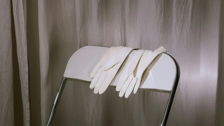 White gloves resting on chair backrest