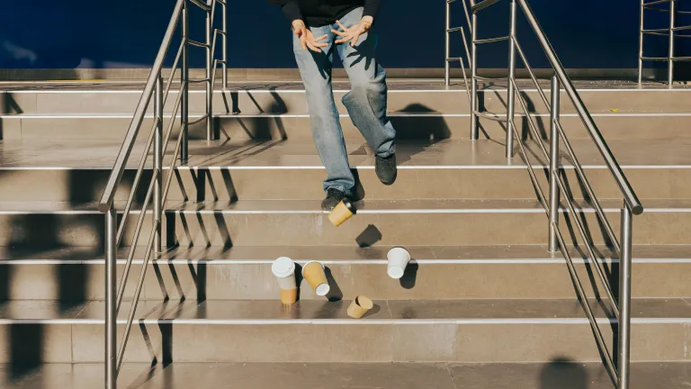 Person dropping coffee cups on stairs