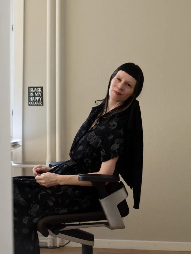 Eine Frau schaut aus ihrer Bürotür heraus