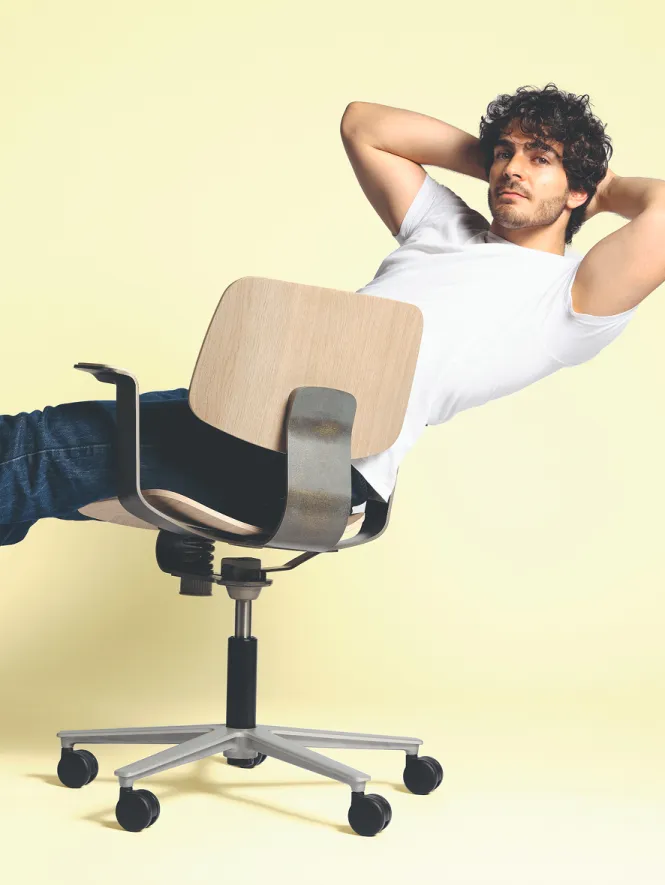 A man is sitting relaxed on the WiChair by Wilkhahn
