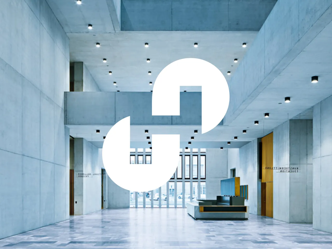 Innenansicht der Erweiterung des Kunsthaus Zürich von Chipperfield. Die große, offene Halle zeigt hoch aufragende Wände aus hellgrauem Recyclingbeton, klare geometrische Linien und eine minimalistische Ästhetik.