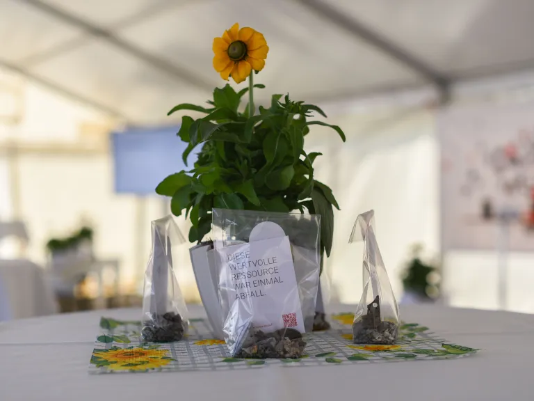 Ein Tisch mit einem Mittelstück aus einer Blume und dem Giveaway von der Produkteinführung.